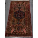 A hand knotted woollen red/blue ground rug, 215 x 107cm.