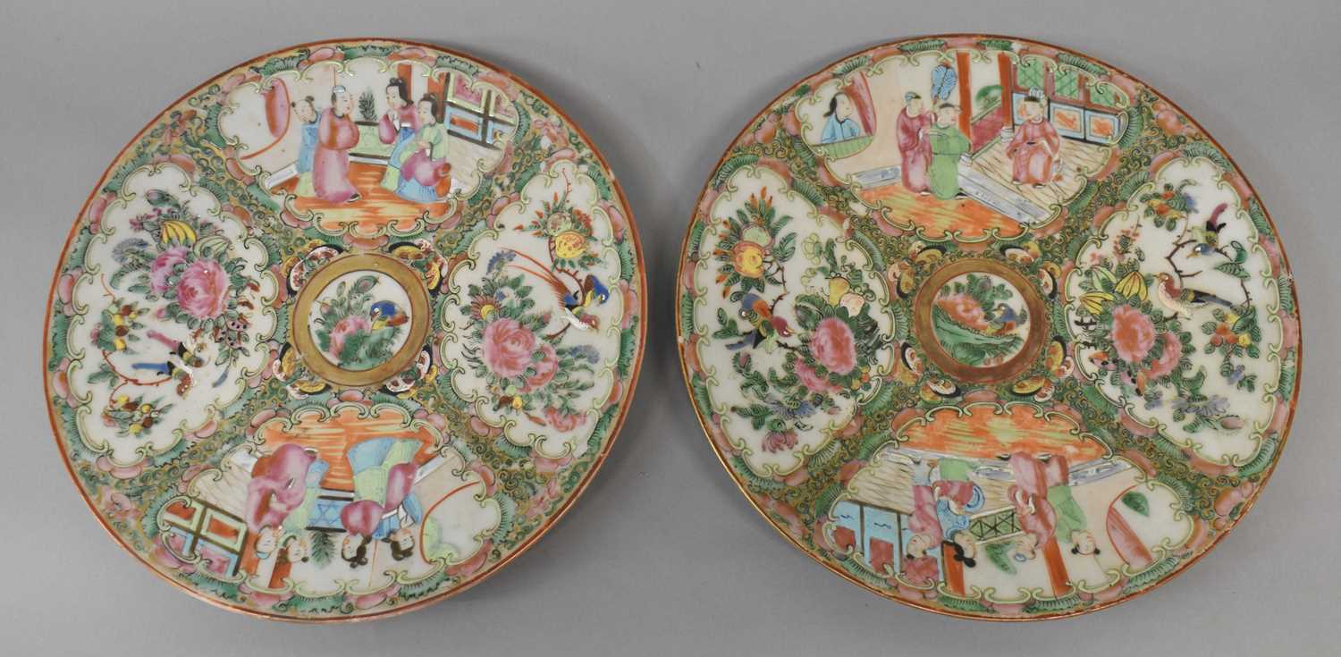 A pair of late 19th century Chinese Canton Famille Rose plates each decorated with four panels