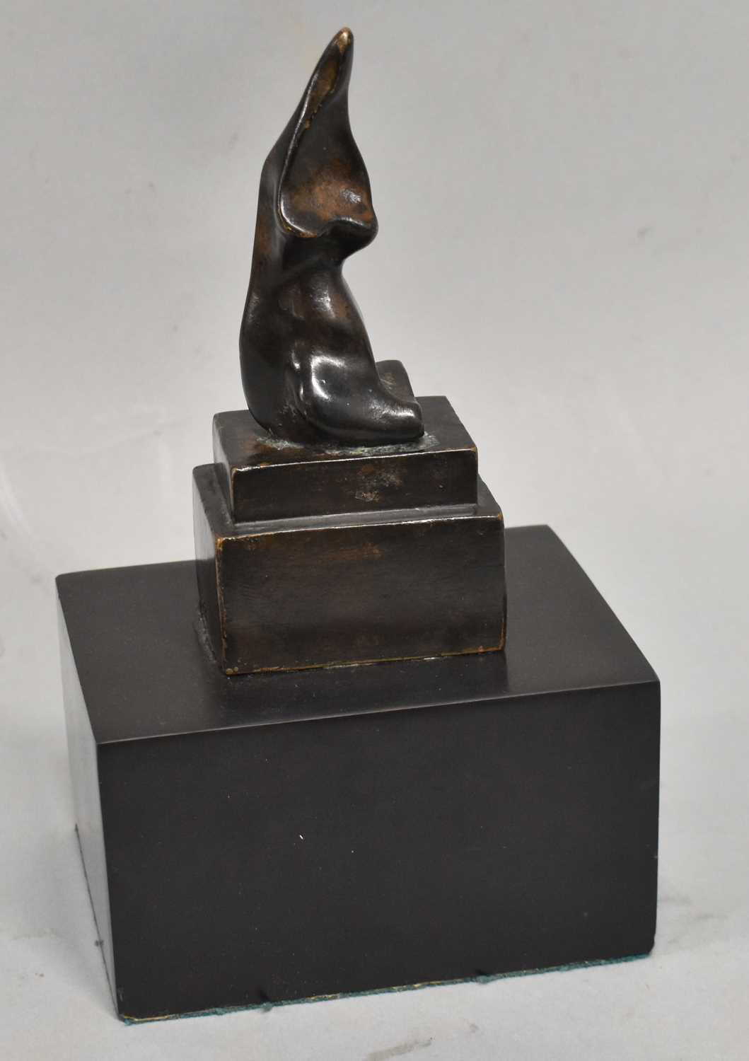 AFTER HENRY MOORE; a bronze of a stylised female torso, bears signature, on substantial base, height