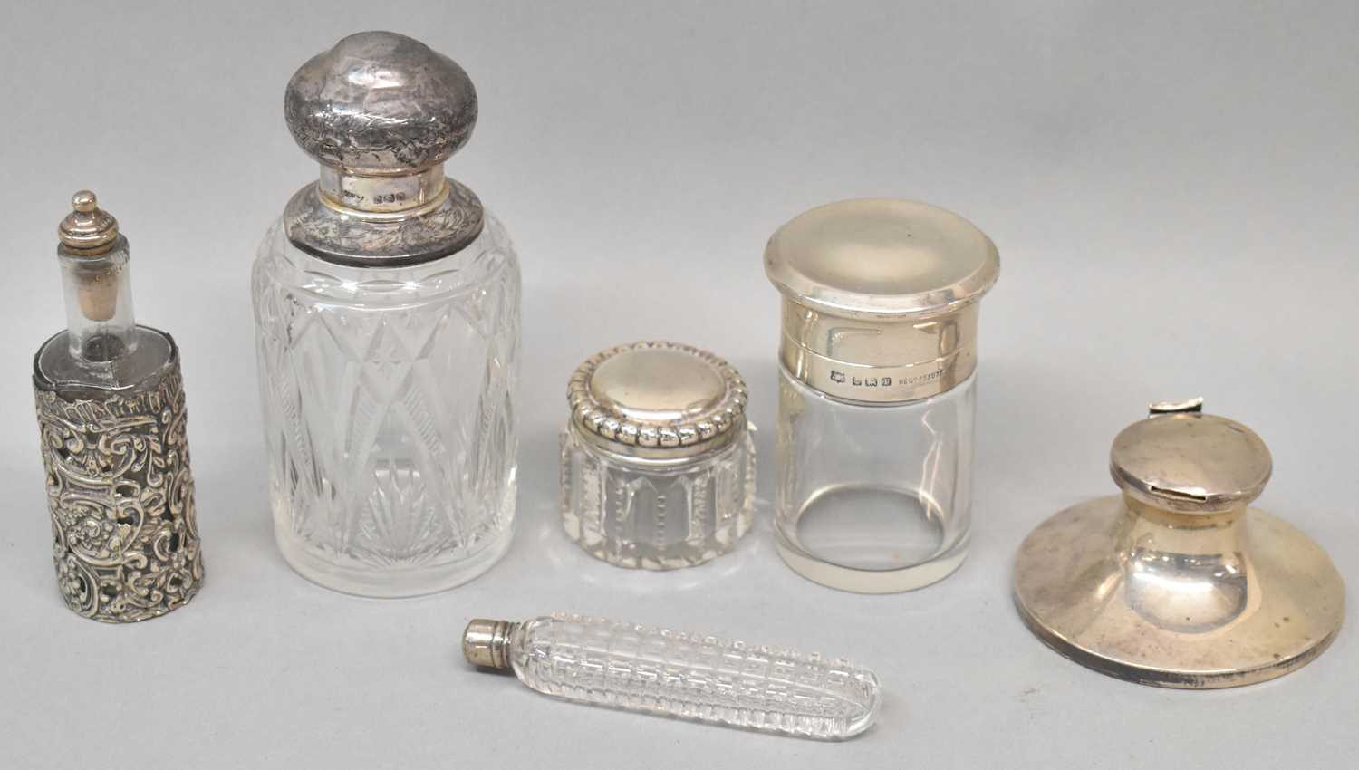 A group of small silver including a clear glass perfume bottle with hinged silver cover, a loaded