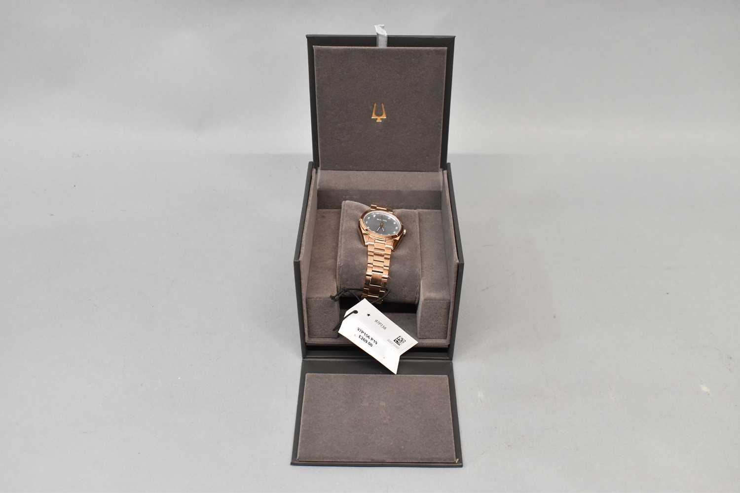BULOVA; a lady's watch with rose gold plated bracelet, grey face and crystal, boxed and unused.