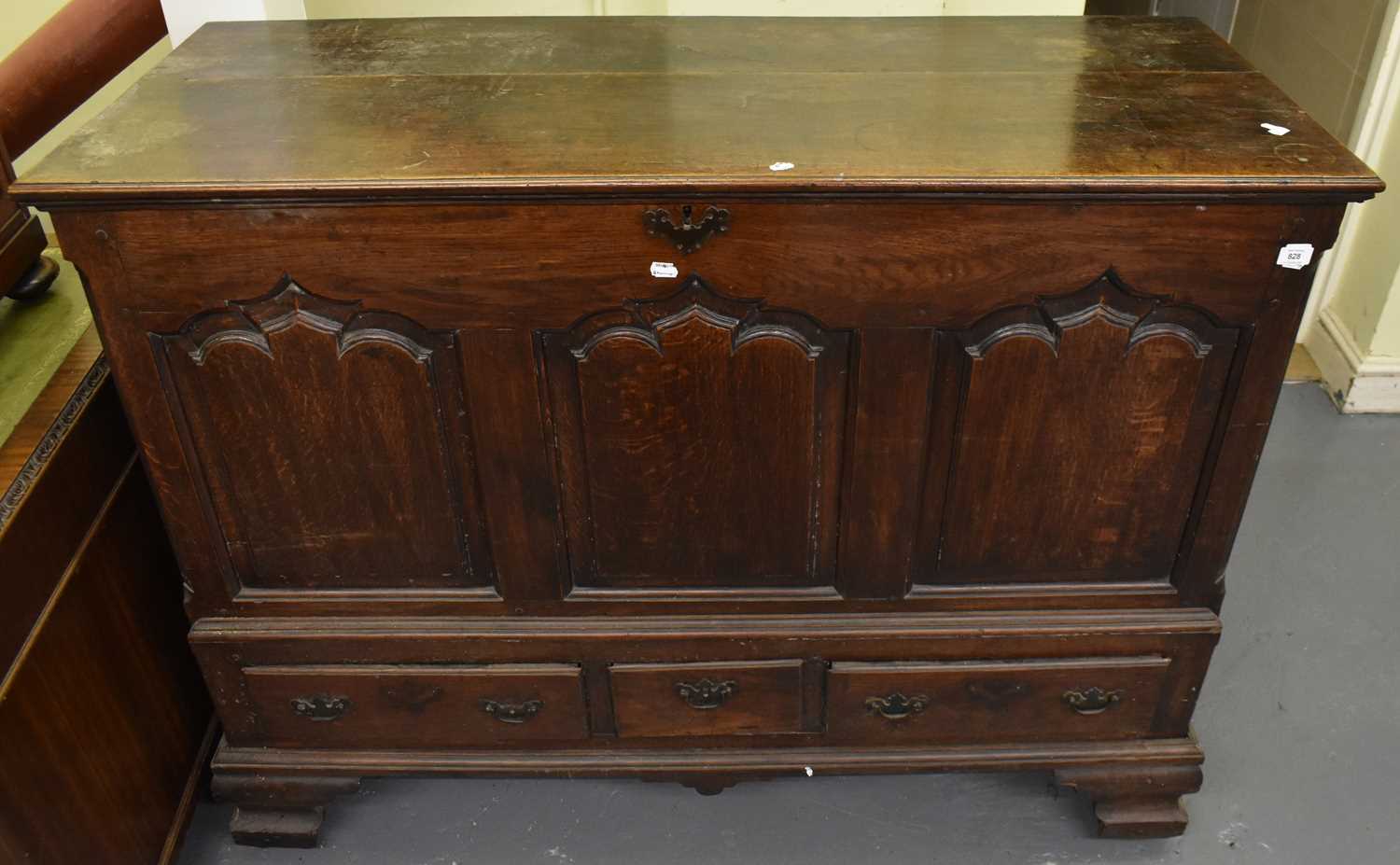 A Georgian oak mule chest, the hinged lid above a three-panel front and three base drawers, on