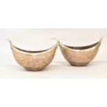 A pair of Kashmir copper and brass boat-shaped begging bowls with interior candle holders, length