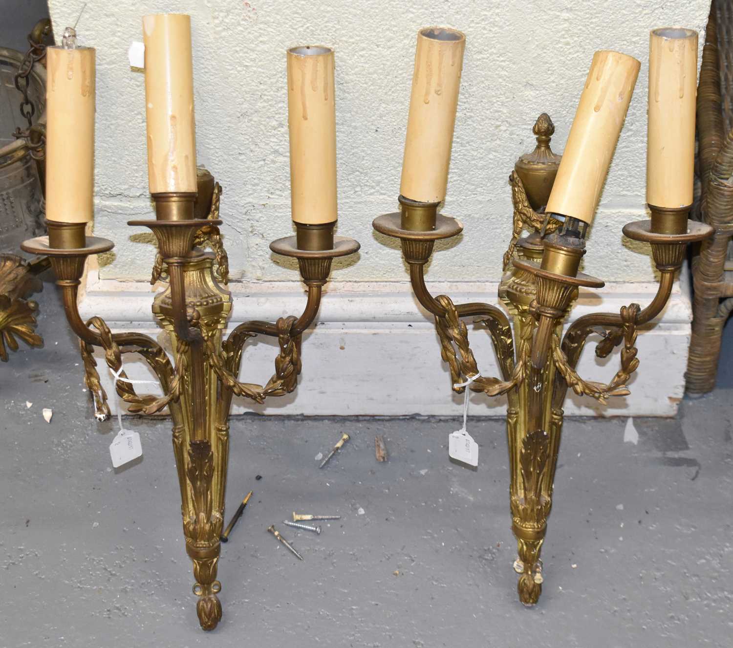 A pair of gilt metal urns, and swag decorated three branch wall lights, height 37cm.