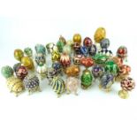 Approximately forty-four miniature Fabergé-style egg trinket boxes, mostly on stands, various