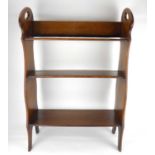 An Arts & Crafts style oak floorstanding bookcase with three shelves and side handle cut-