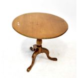 A mahogany circular tilt-top occasional table with birdcage action, raised on turned column and