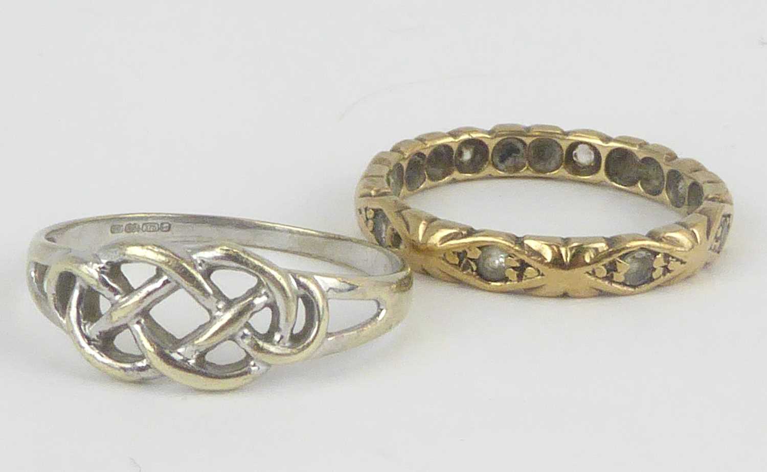 A 9ct white gold Celtic design ring, size Q and a yellow metal eternity ring set with tiny white
