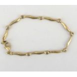 A modern 9ct gold bracelet with wavy bar links separated by eight bezel set tiny diamonds, with