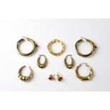 Three pairs of hallmarked 9ct gold earrings comprising bell studs, two large hoops with bevel set