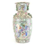 A large late 19th/early 20th century Canton Famille Rose baluster vase with flared neck decorated