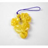 A yellow jade pendant in the form of roses and foliage, length approx 45cm.