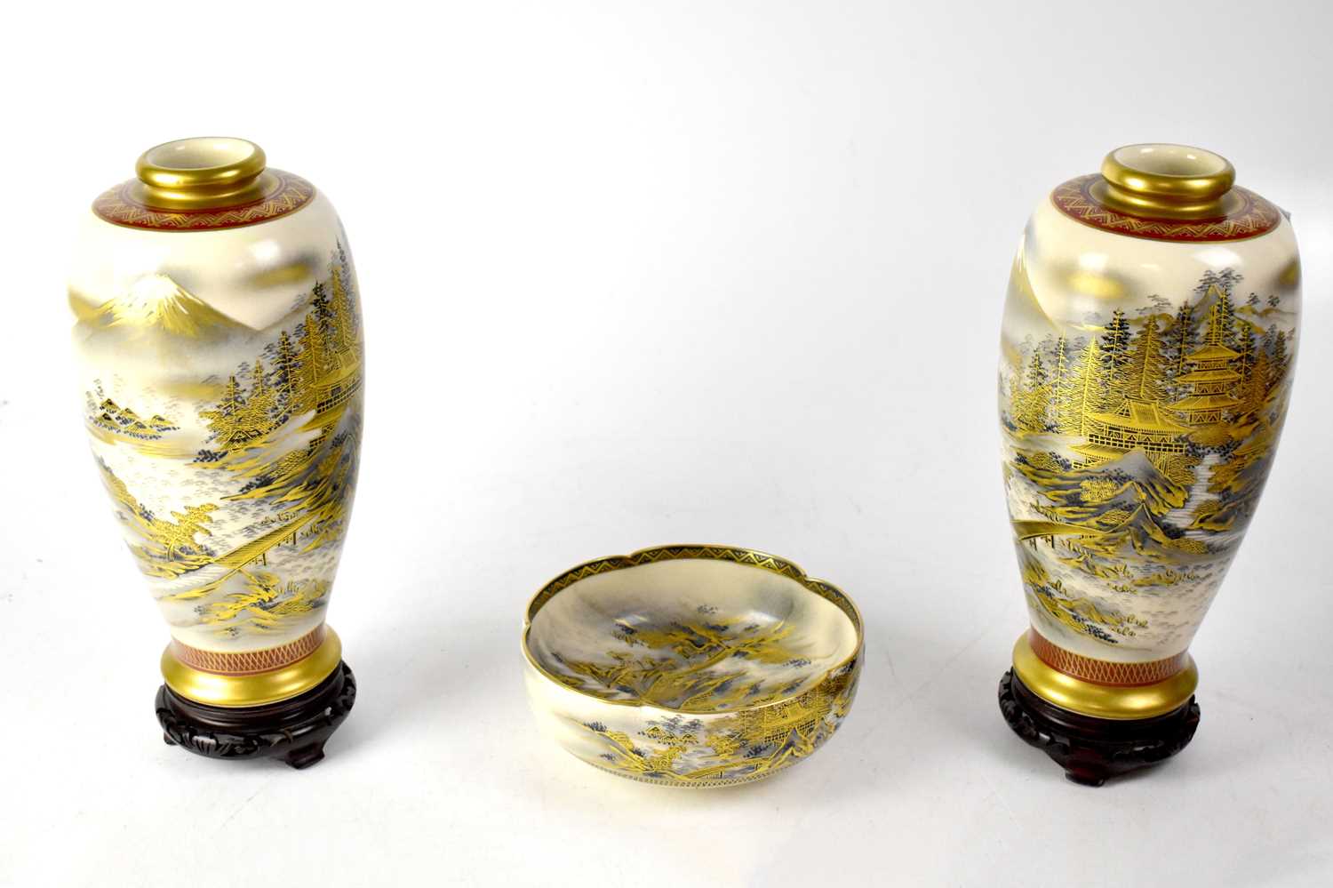 A pair of 20th century Japanese Satsuma tapering vases decorated with scenes of pagodas in the