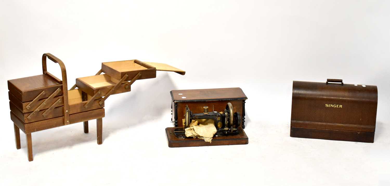 An oak cased Singer sewing machine, one other cased sewing machine and a mid-20th century teak