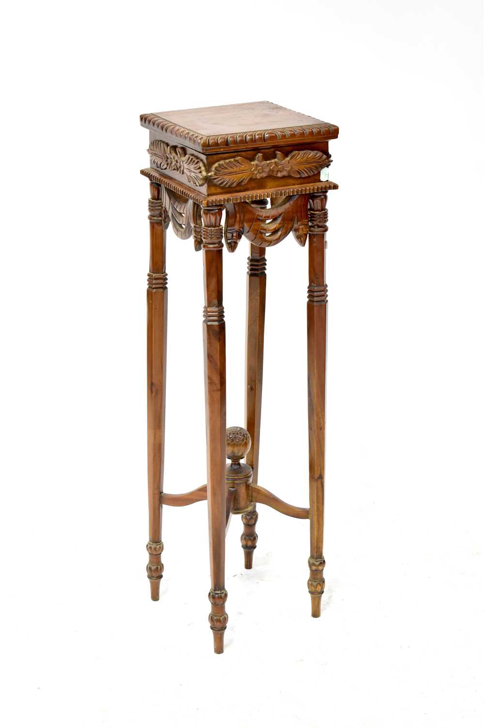 A 20th century mahogany jardinière stand with carved leaf decoration to slender tapering legs and