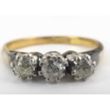 An 18ct gold three-stone diamond ring, the three tiny claw set diamonds on a white metal mount, size