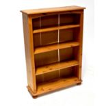 A contemporary pine open bookcase raised on turned bun feet.125 x 88 x 29cm