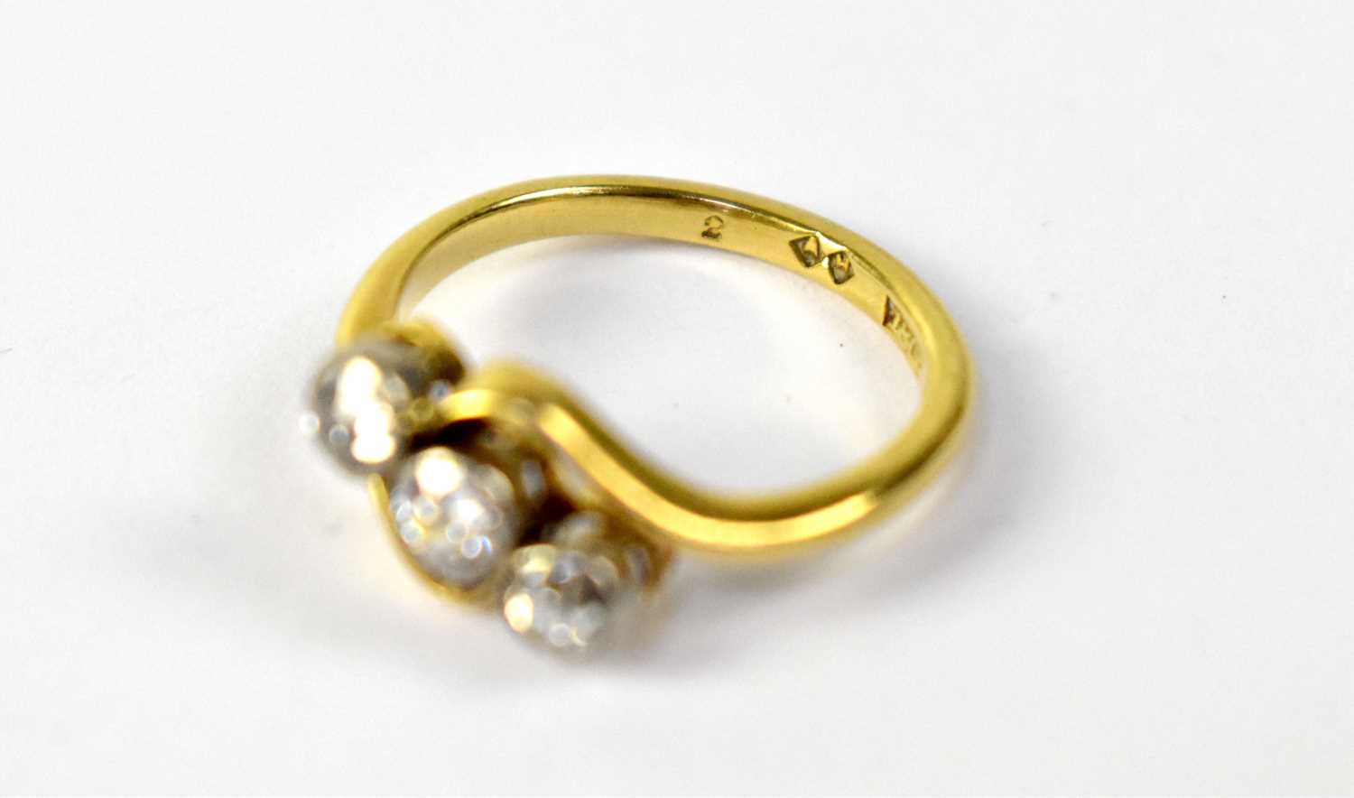 An 18ct gold three-stone diamond cross-over ring, the three white mounted collet set brilliant cut - Image 2 of 2