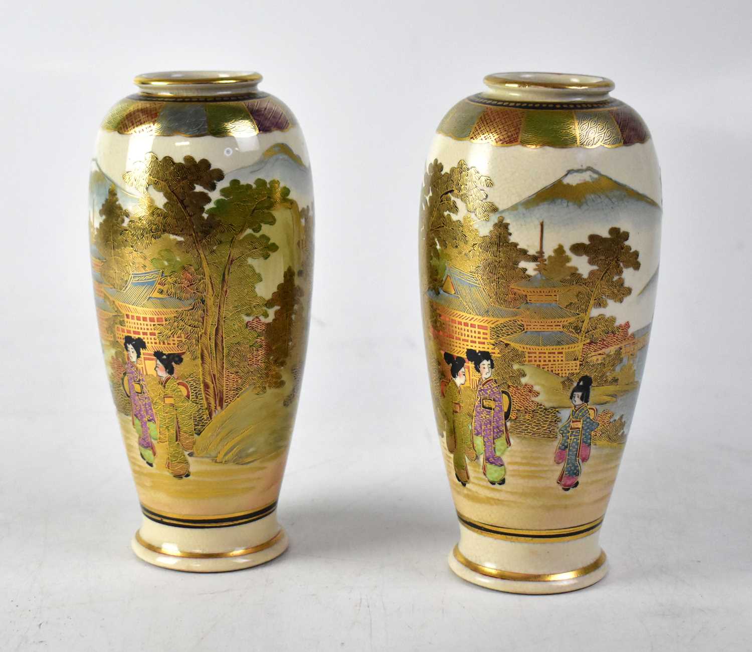 A pair of Meiji period Satsuma slender baluster vases with hand painted figural scenes, pagodas,