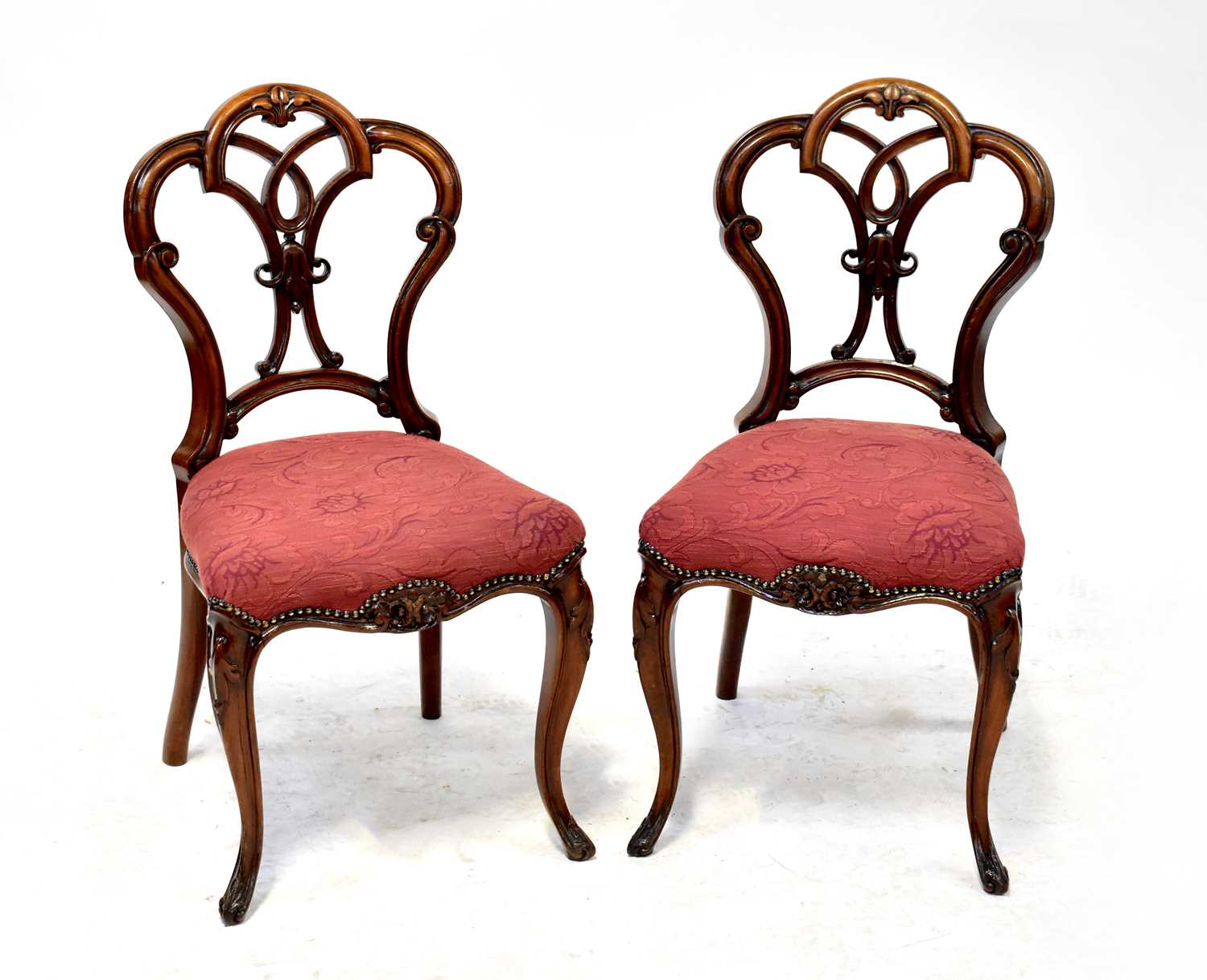 A set of six late 19th century walnut dining chairs with open pierced balloon backs, flowerhead