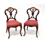 A set of six late 19th century walnut dining chairs with open pierced balloon backs, flowerhead