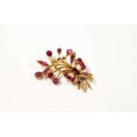 A yellow metal open work brooch in the form of a spray of flowers tied with a bow, set with twenty-