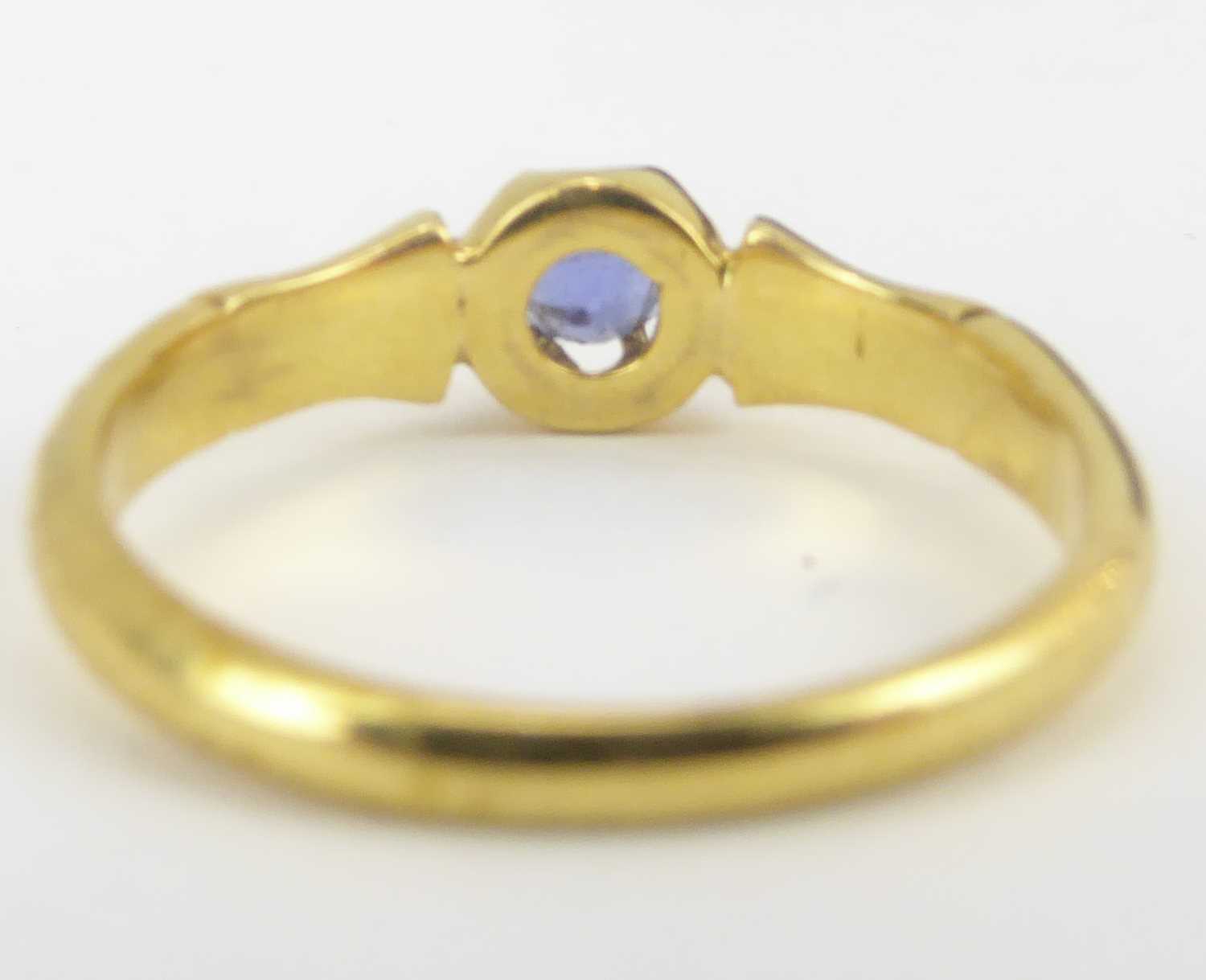 Two 18ct gold dress rings comprising an example with three channel set sapphires separated with