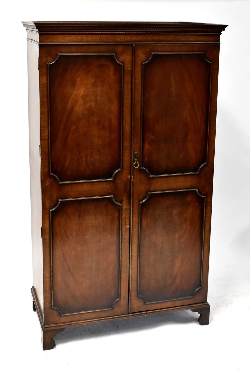 A mid-20th century mahogany wardrobe, stepped frieze above twin doors with panel moulding to