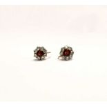 A pair of yellow metal screw fitting earrings, each set with garnet and white stones in a cluster