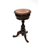 A Victorian walnut teapoy with circular carved top, enclosing a fitted interior of two zinc lined