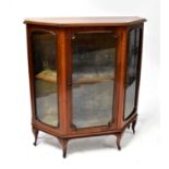 An Edwardian mahogany display cabinet with canted front corners, single glazed door flanked by