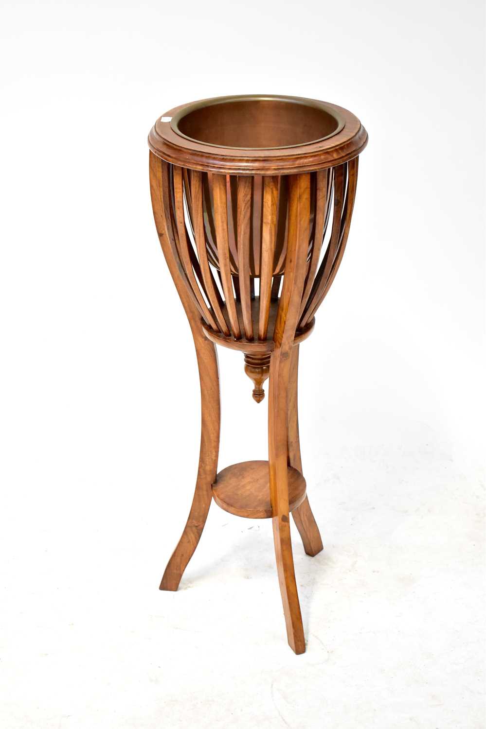 A 20th century mahogany jardinière stand in the form of a brazier with metal plant liner, on three