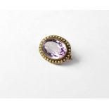 A Victorian oval brooch set with large faceted amethyst with seed pearl surround.