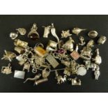 A vintage silver charm bracelet with approximately thirty-four silver charms, to include helicopter,