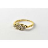 An 18ct gold Art Deco style diamond ring, the central bezel set cut diamond in a white mount,