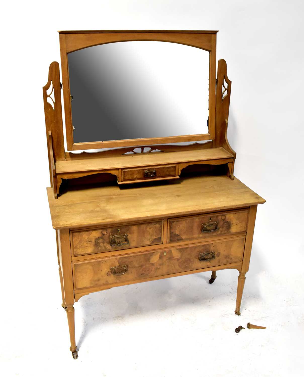 An Edwardian stripped walnut and burr walnut dressing chest with arched mirror above a single frieze