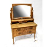 An Edwardian stripped walnut and burr walnut dressing chest with arched mirror above a single frieze