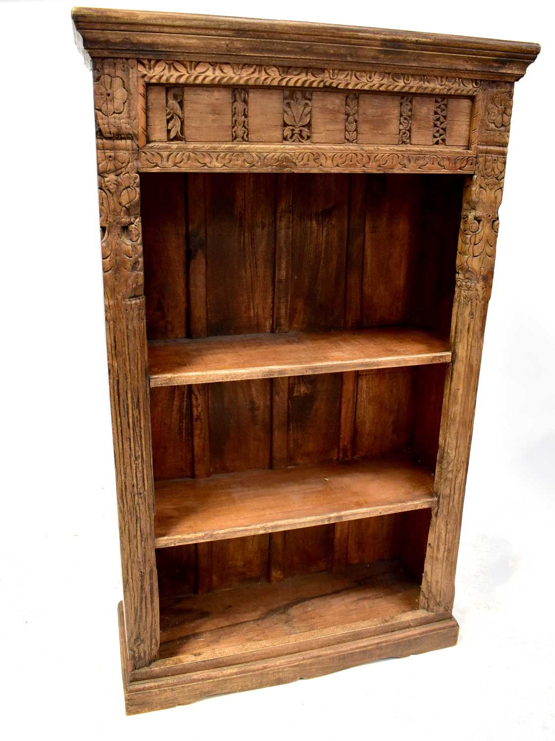 A modern oak rustic-style bookcase with carved detail to the front of floral friezes and quarter