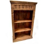 A modern oak rustic-style bookcase with carved detail to the front of floral friezes and quarter