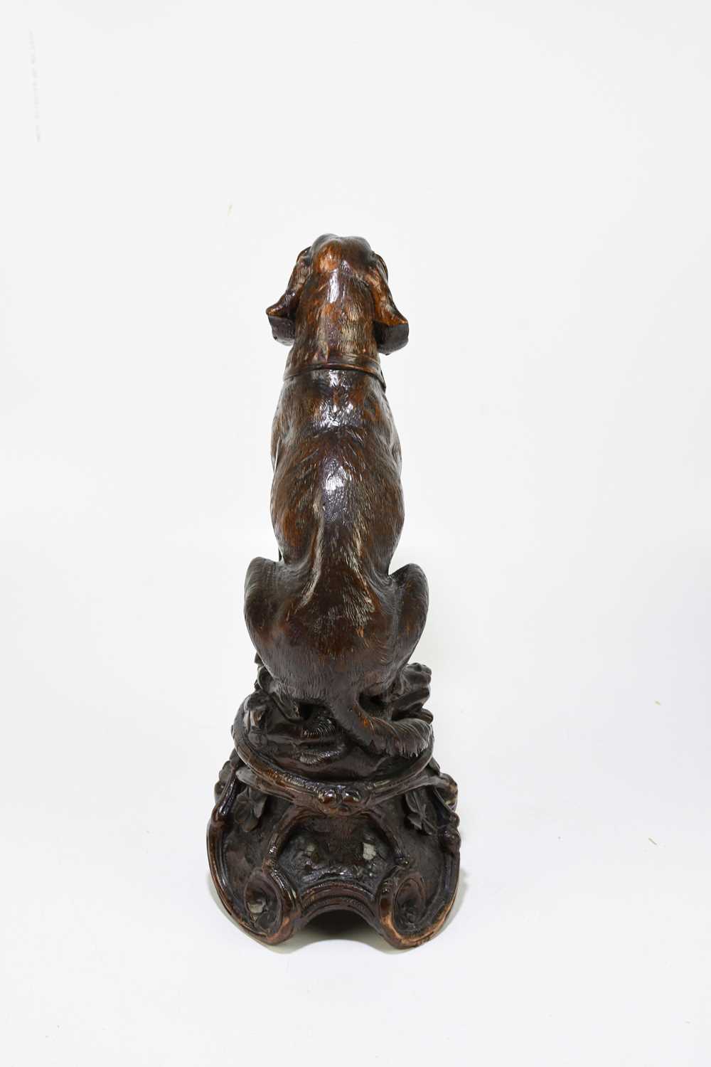 A late 19th century Black Forest large carved soft wood model of a seated dog, on naturalistic - Image 4 of 6