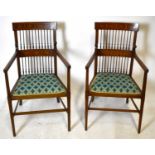 A pair of Edwardian inlaid mahogany spindle back elbow chairs, upholstered with geometric seats,