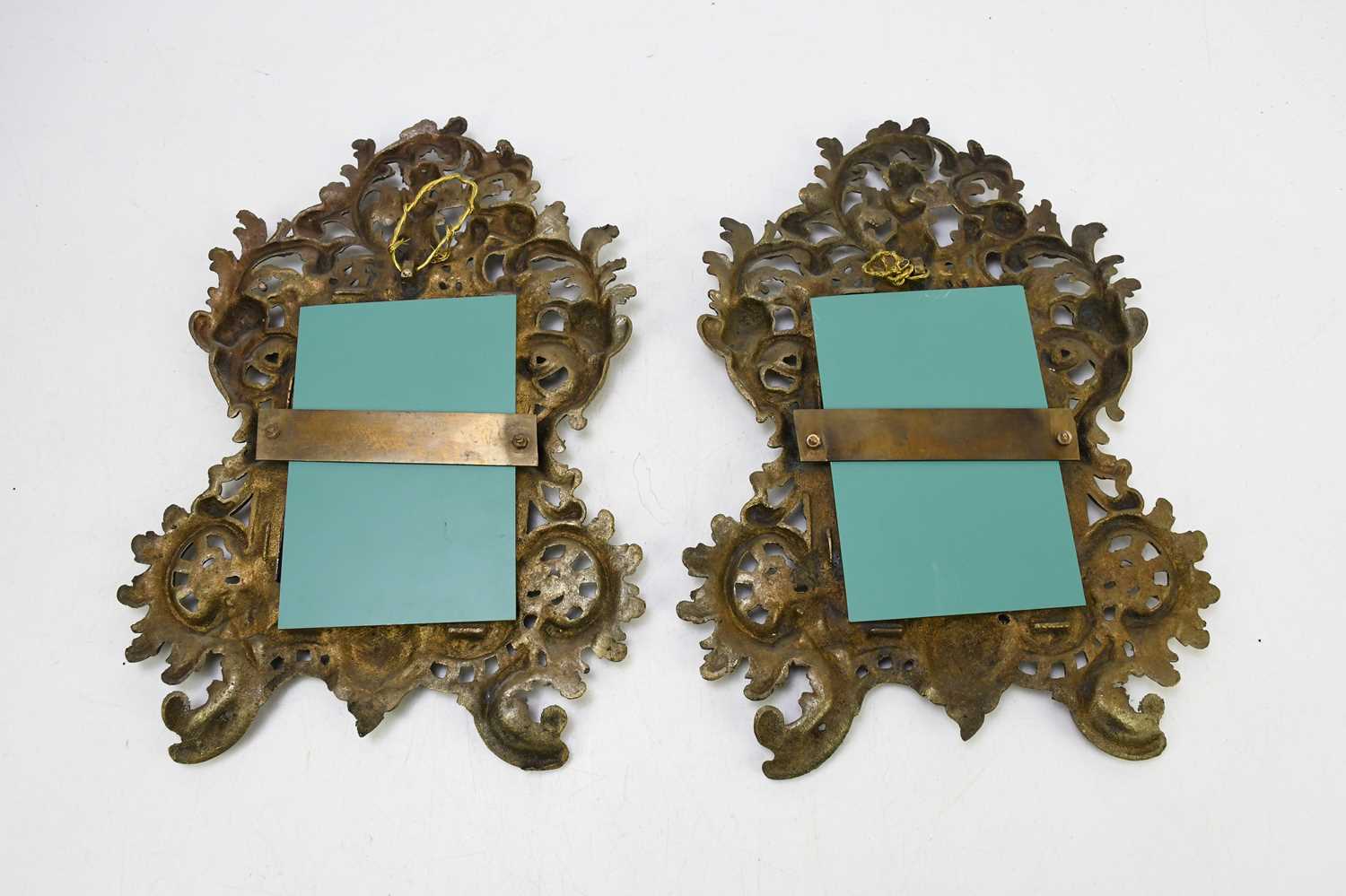 A pair of decorative gilt brass wall mirrors, decorated with cherubs playing the pipes, with - Image 2 of 2