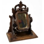 A Black Forest shaving mirror, with carved detail and swivel central mirror, height 25cm.Condition