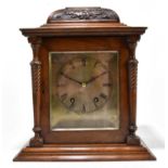 A late Victorian walnut eight day mantel clock, the silvered dial with Roman numeral chapter ring