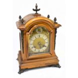 A German walnut eight day mantel clock with brass applied detail and arched brass dial, height