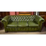 A green leather Chesterfield three seater sofa on turned bun feet, width 199cm, depth 90cm.