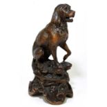 A late 19th century Black Forest large carved soft wood model of a seated dog, on naturalistic