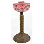 A Victorian brass oil lamp with detachable cranberry glass reservoir painted in enamels with