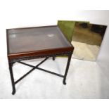 A Chinese carved hardwood bijouterie table/display table with mirrored panel on folding base, with