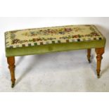 A reproduction long footstool with needlework tapestry top, decorated with floral sprays on turned